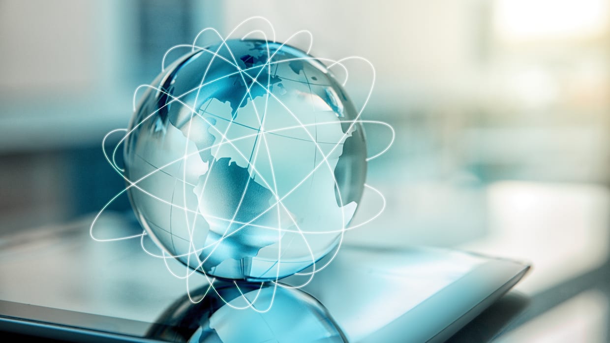 A blue globe sitting on top of a tablet computer.