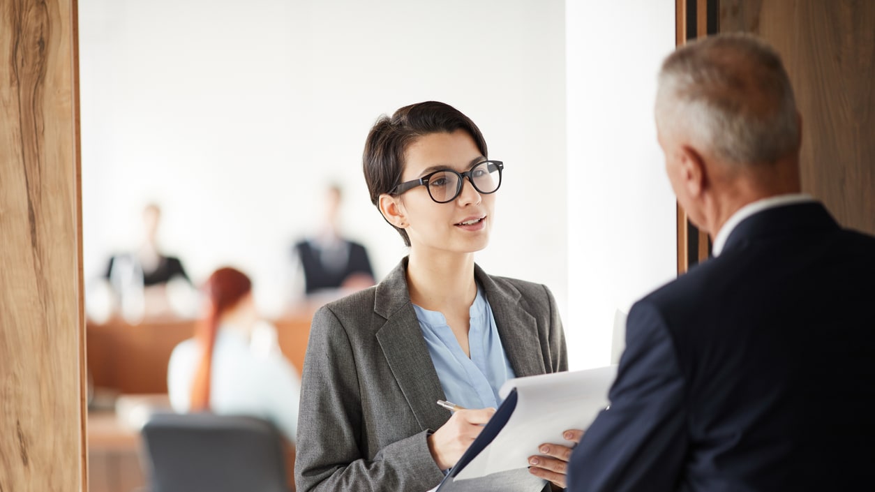 Two business people talking to each other in a courtroom.