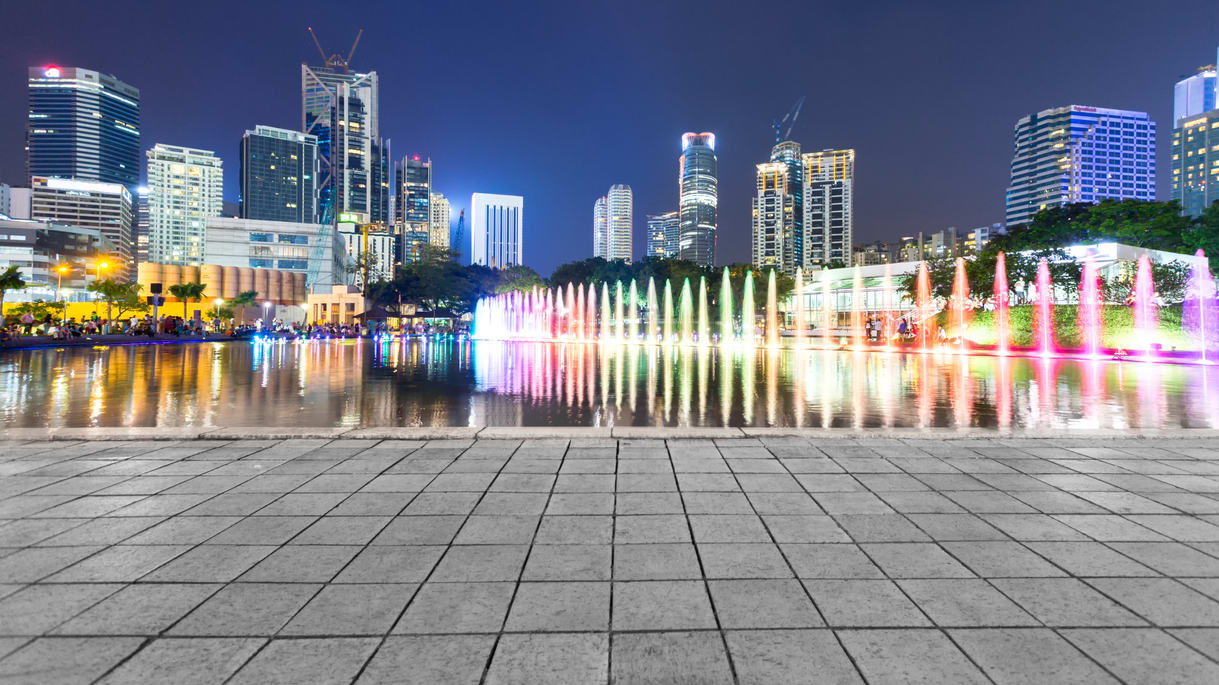 An image of a city at night with a fountain.