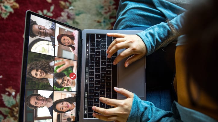 A woman is using a laptop with a group of people on it.