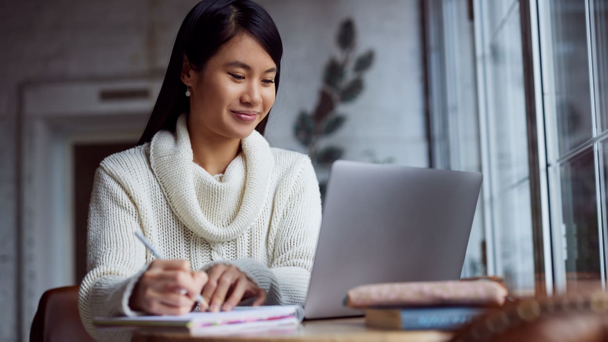 A woman sitting at a table with a laptop.