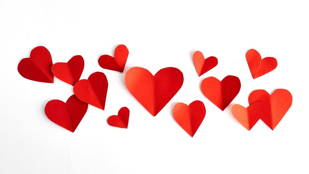 Red paper hearts on a white background.