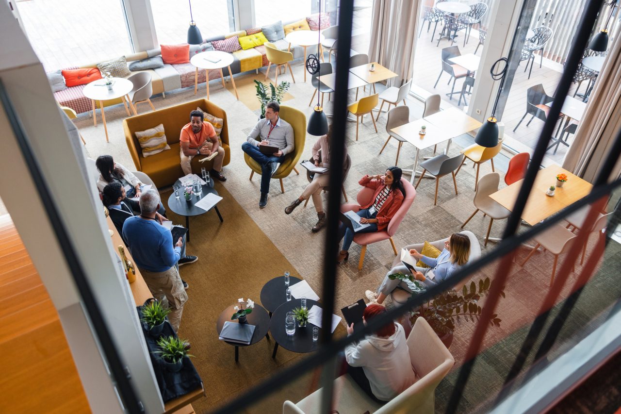 Looking down through a window on a circle of people in an office. 