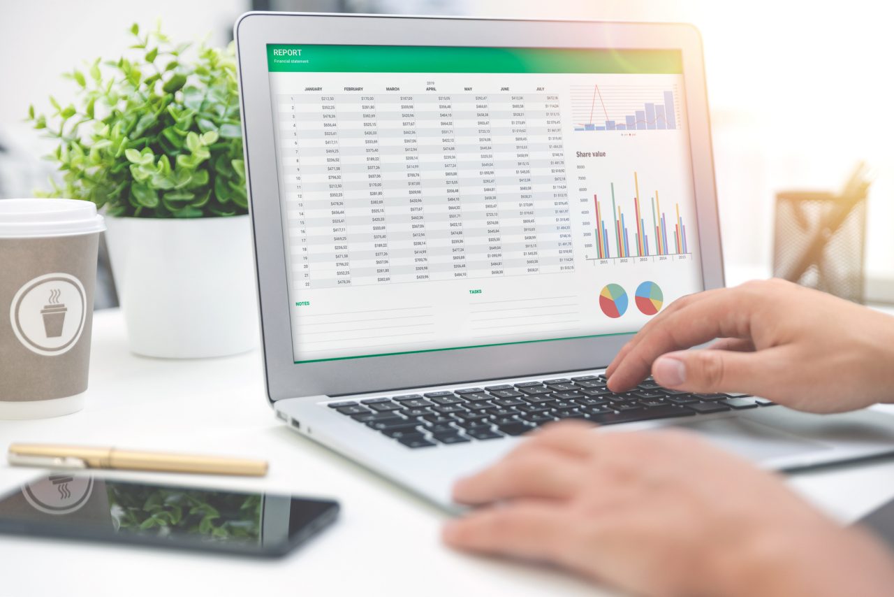 A laptop with a budget spreadsheet and charts on the screen. 