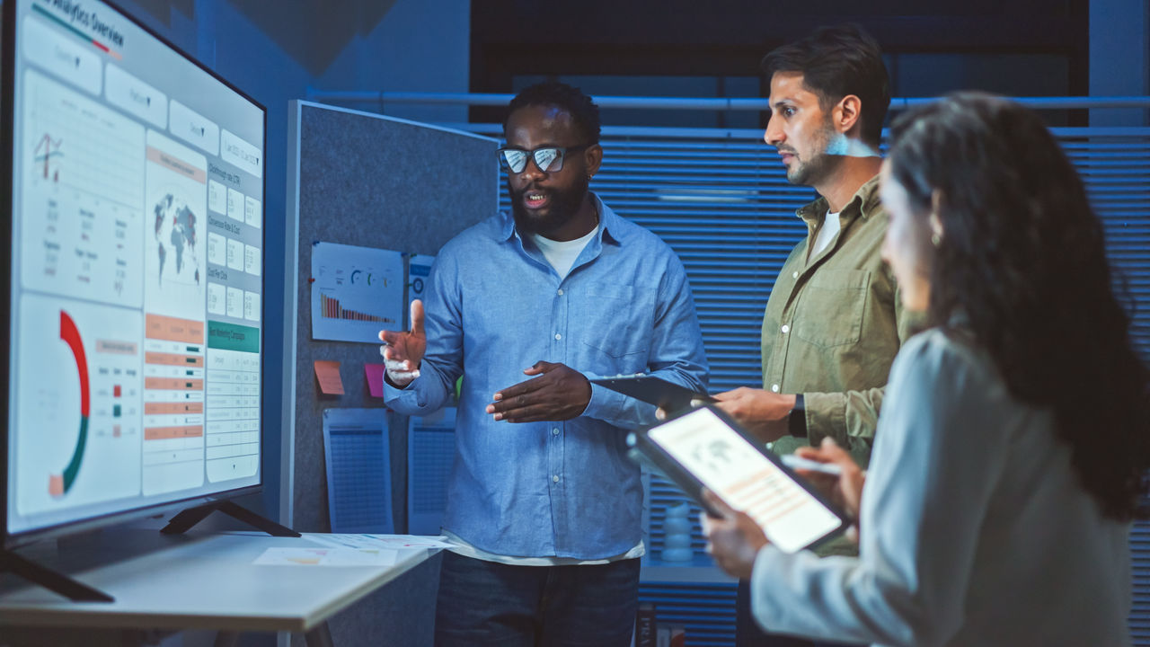 A team of multiethnic developers is meeting to review the data analysis of marketing from social media platforms.