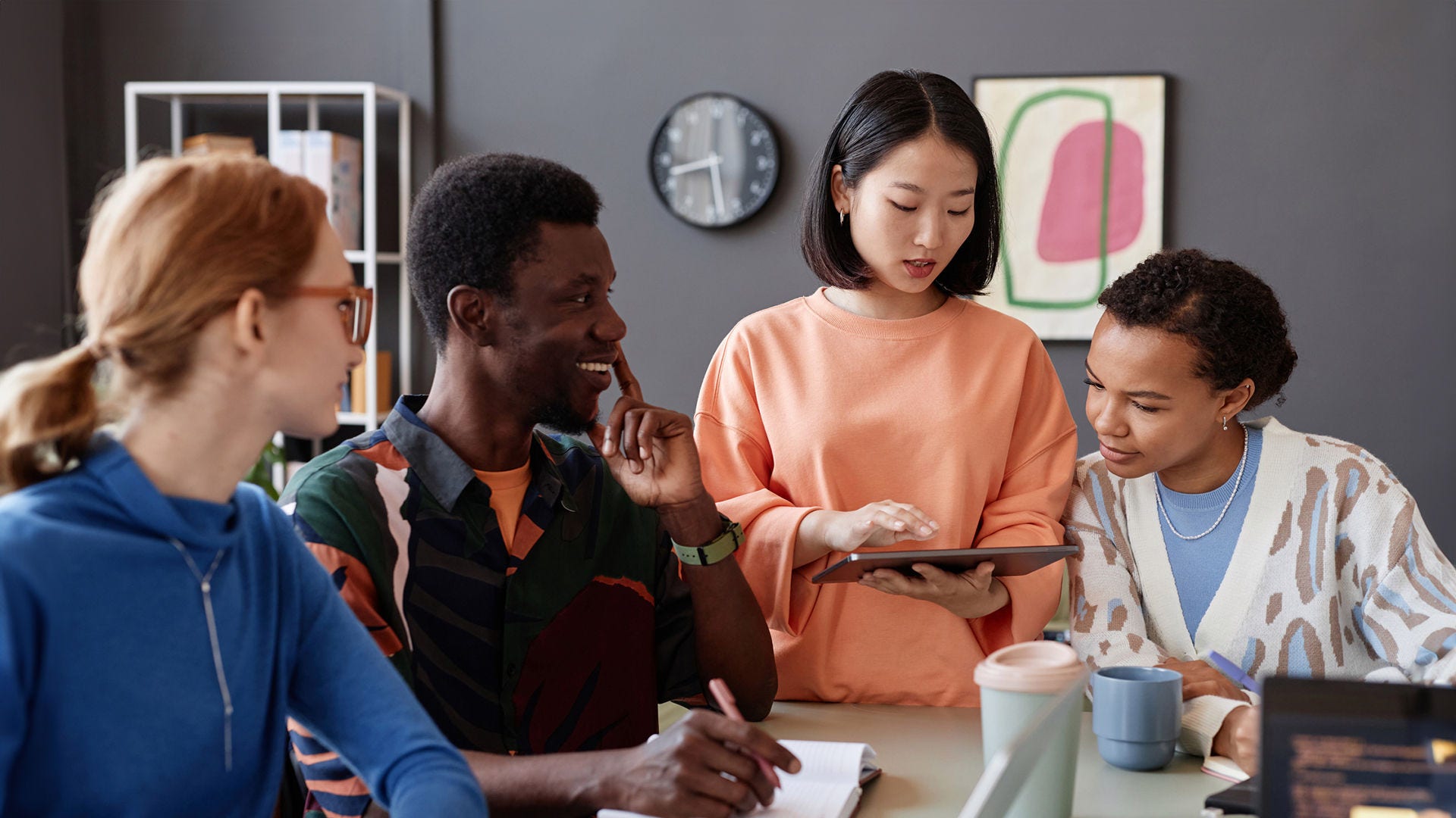 1726236739 a group of casually dressed coworkers collaborates over a tablet