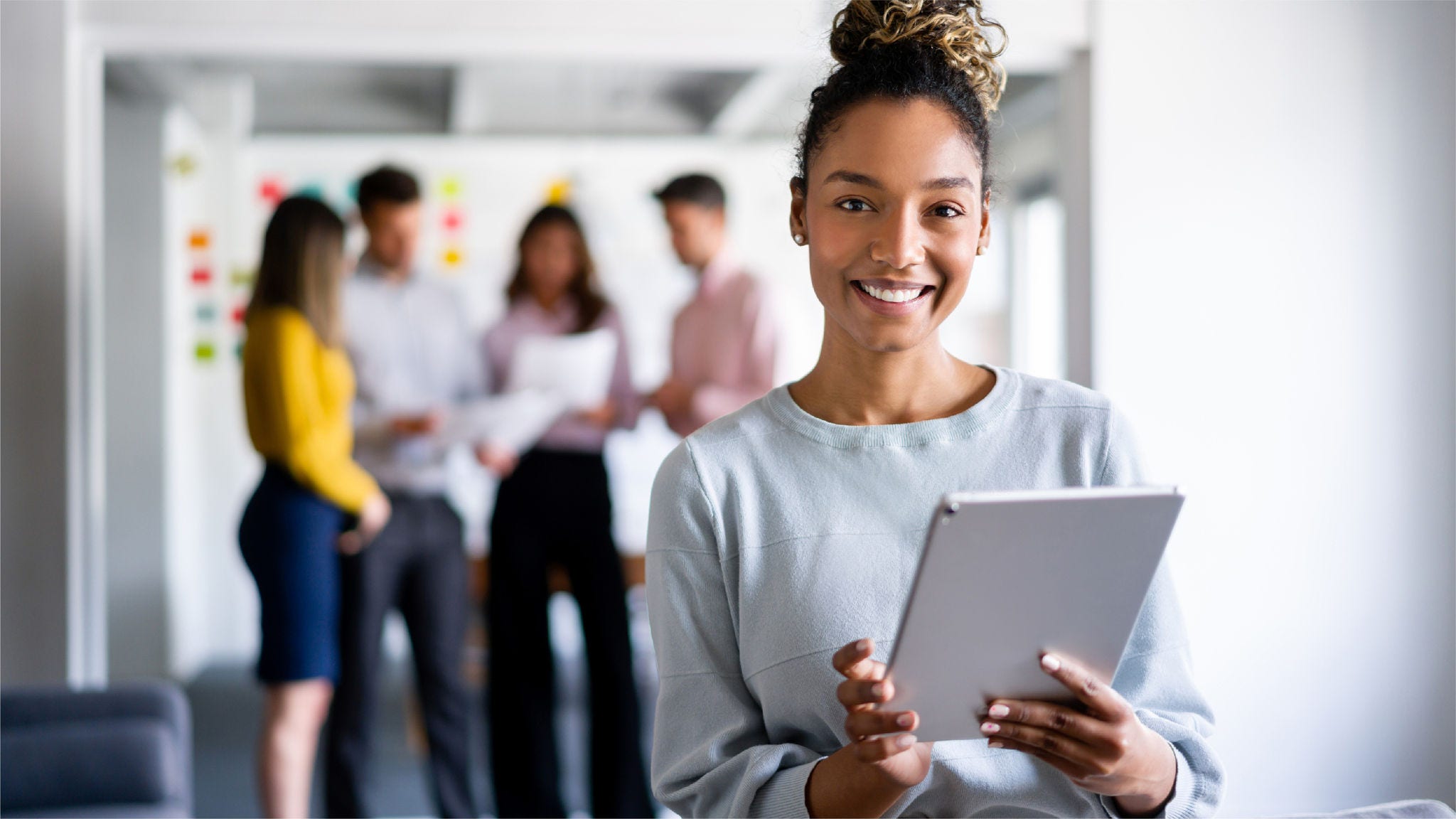 Woman works on her tablet with her team