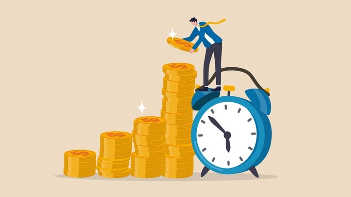 A businessman standing on a stack of coins and an alarm clock.