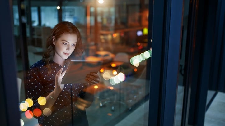 A woman looking out of a window at night.