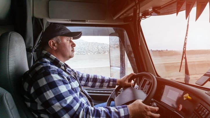 A man sitting in the driver's seat of a truck.