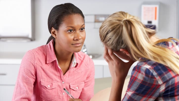 A woman is talking to another woman in a office.