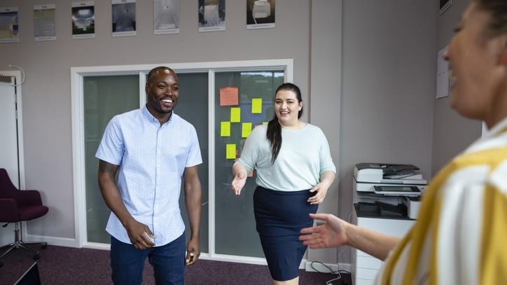 A group of people in an office talking to each other.