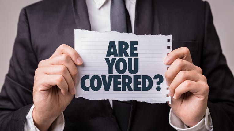 A man holding up a piece of paper with the words are you covered?.