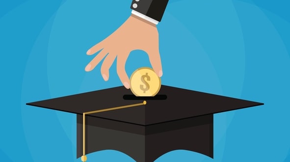 A hand putting a coin into a graduation cap.