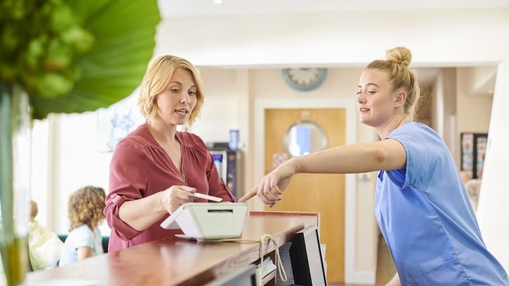 A nurse at the front desk of a hospital.