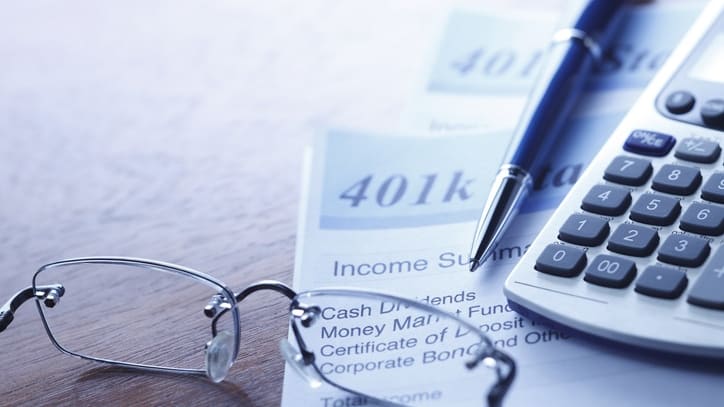 A calculator and glasses sit on top of a tax form.