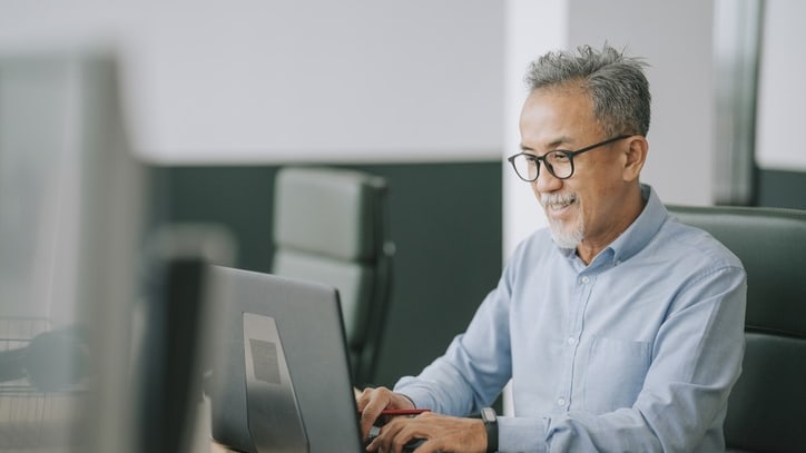 A man working on a laptop in an office.
