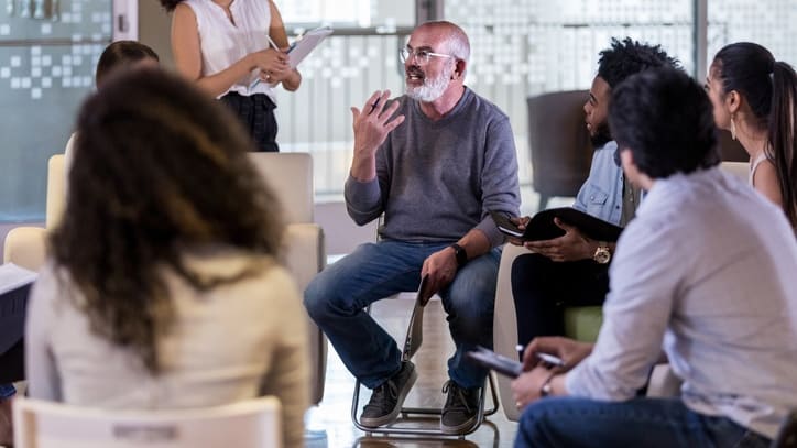 A group of people sitting around a table in a conference room.