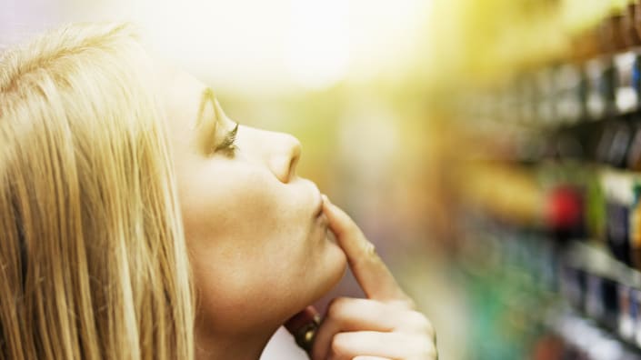 A woman is looking at the shelves in a grocery store.