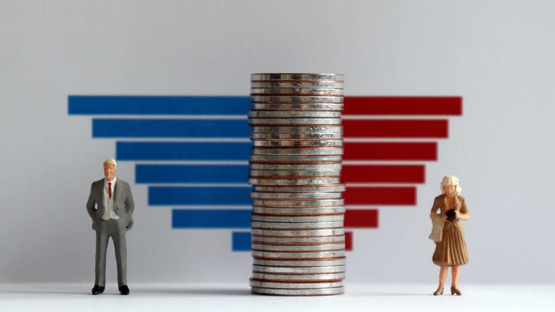 A man and woman standing next to a stack of coins.