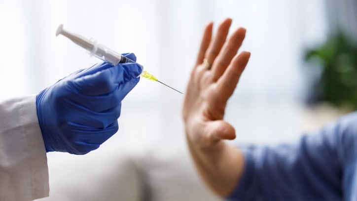 A doctor giving a syringe to a patient.