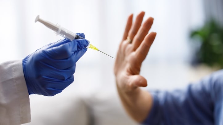 A doctor giving a syringe to a patient.