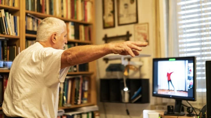 An older man is playing a video game on his computer.