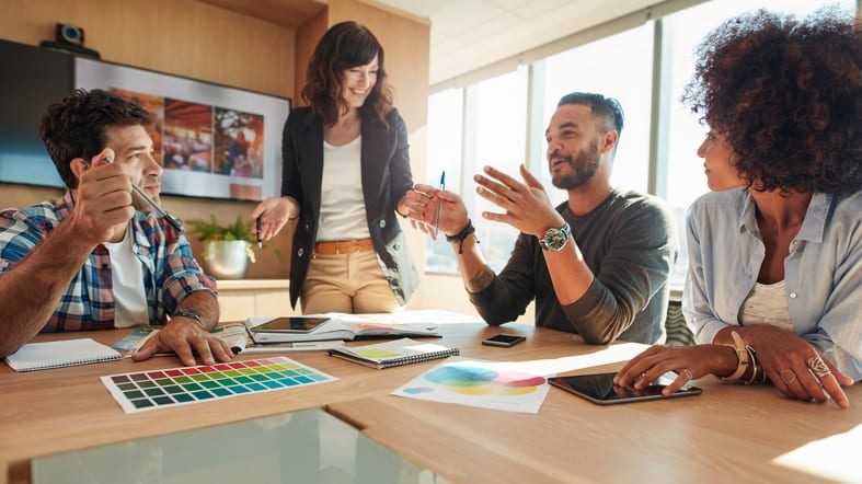 A group of people sitting around a table in a meeting.