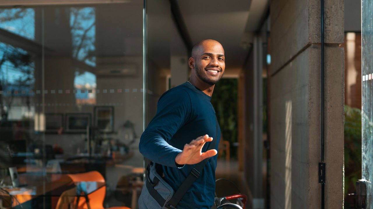 A man is standing in front of a glass door.