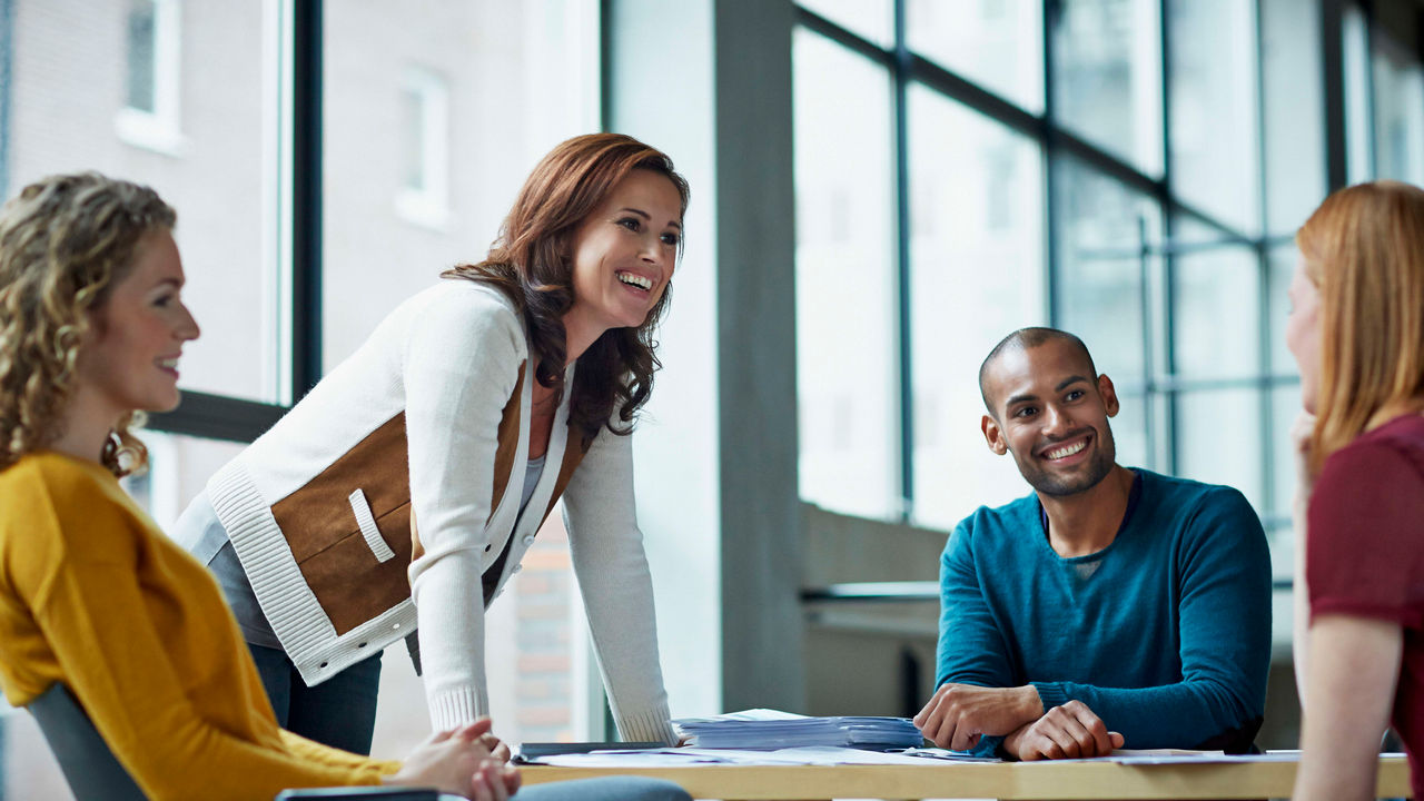 A group of people sitting around a table in an office.