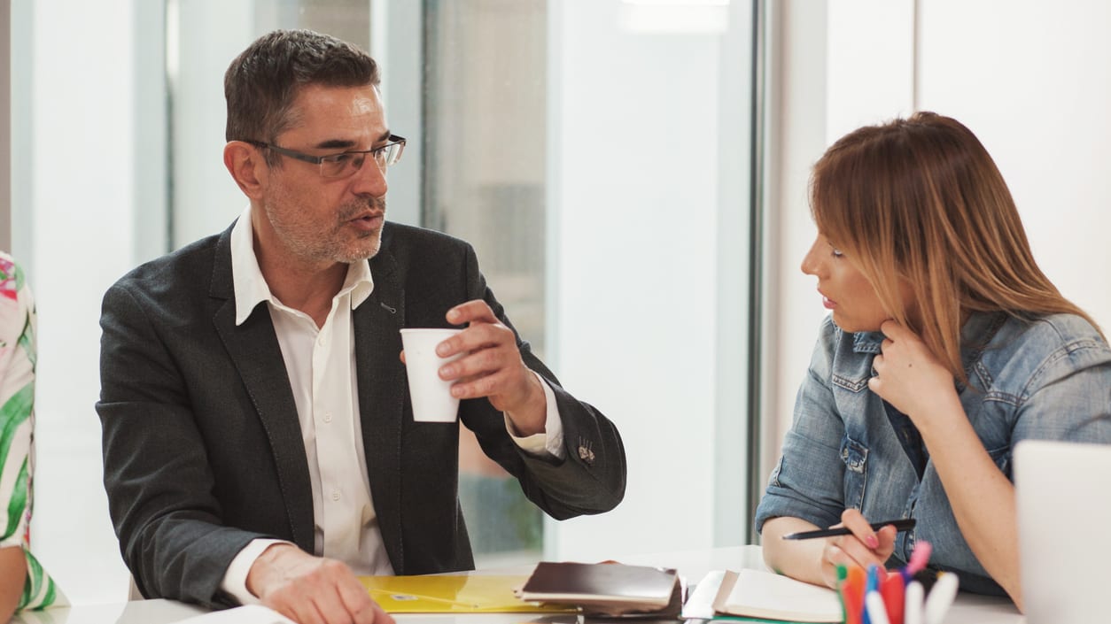 A group of people sitting around a table having a meeting.