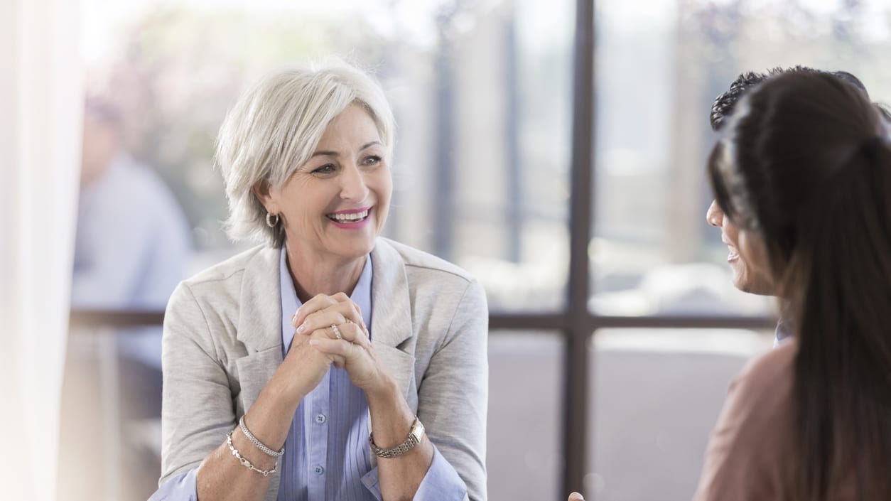 Two women talking at a table in an office.