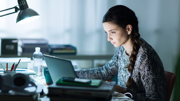 A woman working on her laptop at night.