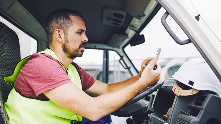 A man sitting in the driver's seat of a truck.