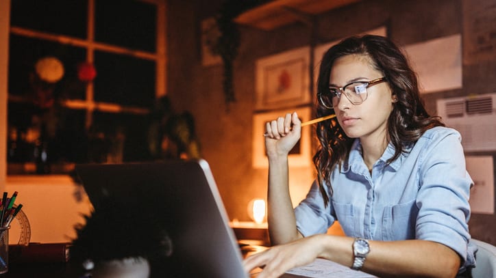 A woman working on her laptop at night.