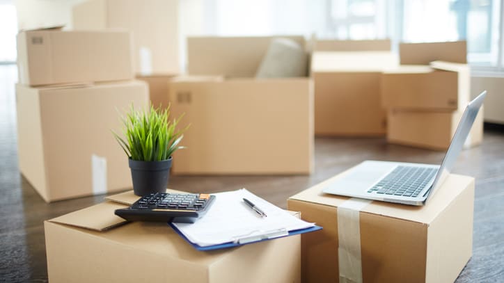 Moving boxes and a laptop in an office.