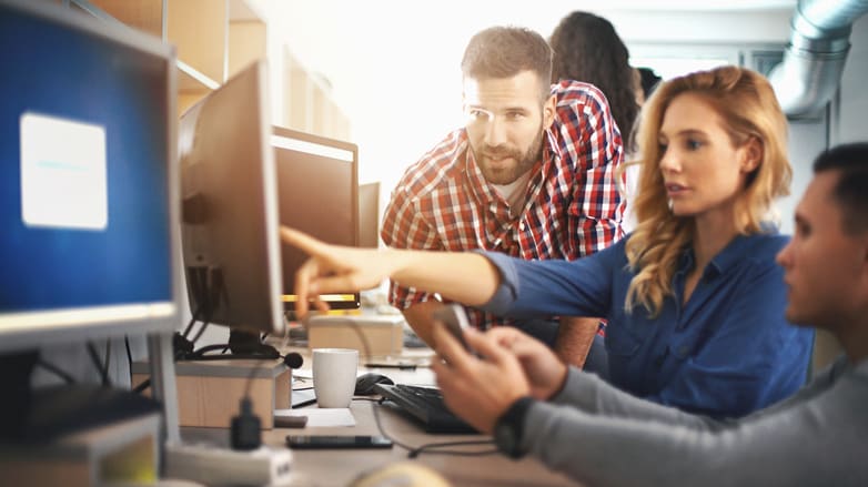 A group of people working on computers in an office.
